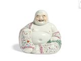 une figurine représentant un Bouddha souriant assis sur un coussin