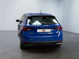 the rear end of a blue car parked in a white room