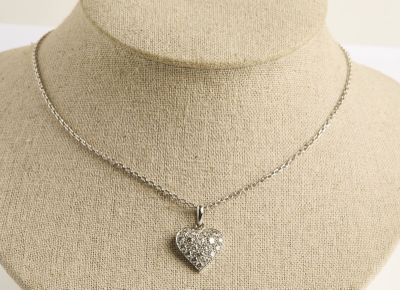 collier avec un cœur en argent, accroché à une chaîne autour du cou d'un mannequin