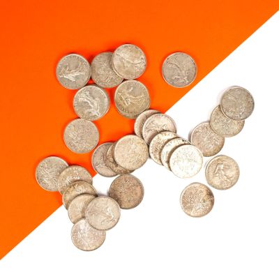 un tas de pièces d'argent sur un fond orange et blanc