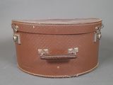 a brown suitcase sitting on a gray surface