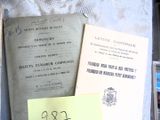 beaucoup de vieux livres posés sur une table, sur laquelle se trouve un bout de papier