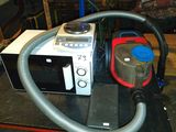 un micro-ondes et un aspirateur posés sur une table dans une pièce