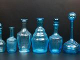 beaucoup de bouteilles en verre bleues posées sur une table