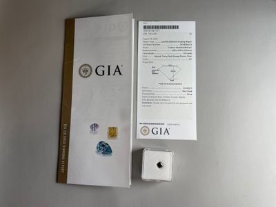 a close up of a box containing a diamond and a piece of paper