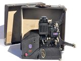 un vieux projecteur de cinéma posé dans une valise ouverte