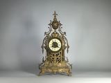 une horloge en or posée sur une table blanche