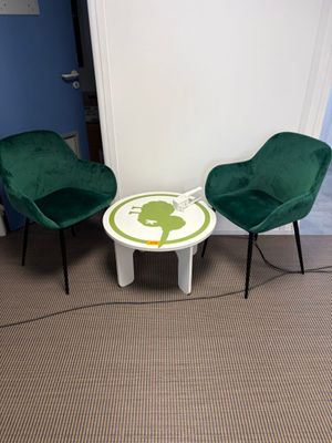 deux chaises vertes et une petite table dans une pièce