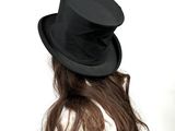 a woman wearing a black hat and a white shirt