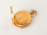 an image of a gold pocket watch on a white surface