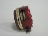 a close up of a fishing reel on a white surface