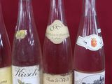 six bouteilles de vin sont alignées sur un fond rouge