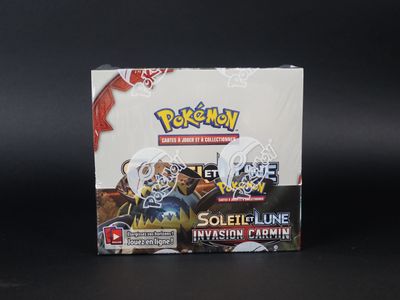 un gros plan d'une boîte de cartes Pokémon posée sur une surface noire
