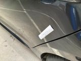 a sticker on the front of a car that is parked in a parking lot