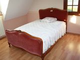 a bed with a red headboard in a small room