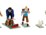 five figurines of people with backpacks and a dog