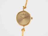 a close up of a gold wrist watch with a chain around it