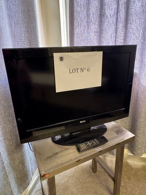 une télévision posée sur une table sur laquelle est inscrit « lot ' n 6 »