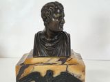 statue d'un homme tenant un oiseau, posée sur un bloc de marbre