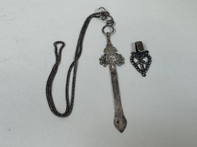 un collier orné d'une croix, à côté d'une clé