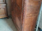 a wooden armoire next to a cabinet in a room