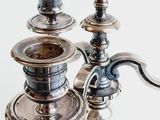 a silver candle holder with two candles on top of it