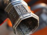a close up of a bike handle with a metal object on it