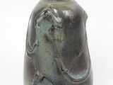 un vase vert orné d'une image représentant une femme