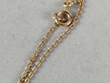 a close up of a gold plated necklace with a chain