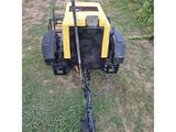 a close up of a yellow and black machine in the grass