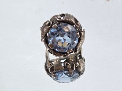 a close up of a ring with a blue stone in it