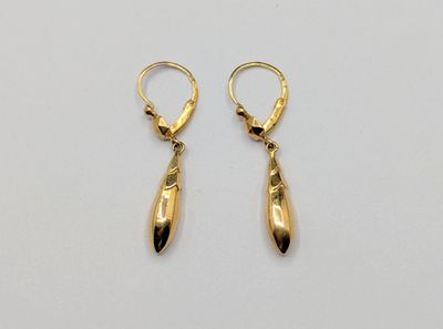 une paire de boucles d'oreilles en or sur fond blanc