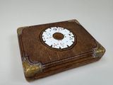 une petite boîte en bois ornée d'un motif blanc et marron