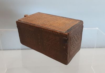 une vieille boîte en cuir marron posée sur une table blanche
