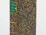 un livre à la couverture verte posé sur une surface blanche