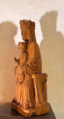 une statue de femme tenant un bébé sur une table