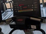 a laptop sitting on a tread machine in a gym