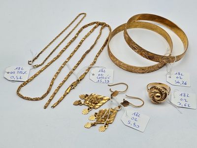 Plusieurs bijoux en or sont exposés sur un fond blanc