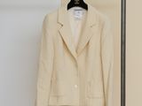 a white jacket hanging on a clothes rack in a room