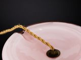 a pink plate with a rope on top of it