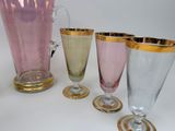 several different colored glasswares are sitting on a white surface