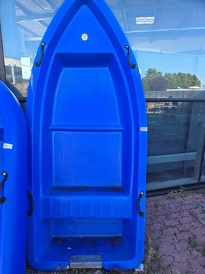 two blue boats sitting next to each other on the side of the road