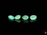 three green glow stones sitting on top of a black surface