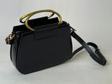 a black purse with a gold handle on a white background