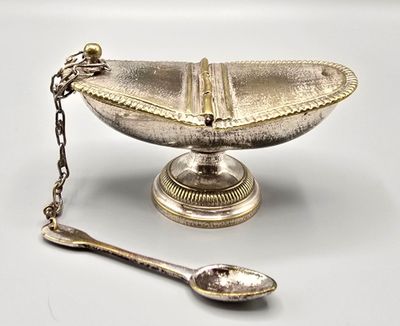 a silver plate with a spoon and spoon rest on it