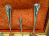 trois cuillères en argent dans un coffret en bois posé sur une table