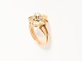 a close up of a gold ring with a flower on it