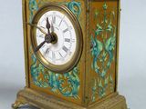 a gold clock with a blue and green design on it