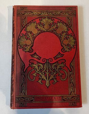 an old red book sitting on top of a white table