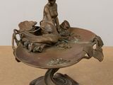 statue of a woman sitting on top of a bowl with a dog